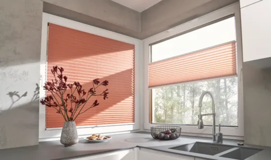 Moderne Küche mit orangefarbenen Plissees an den Fenstern