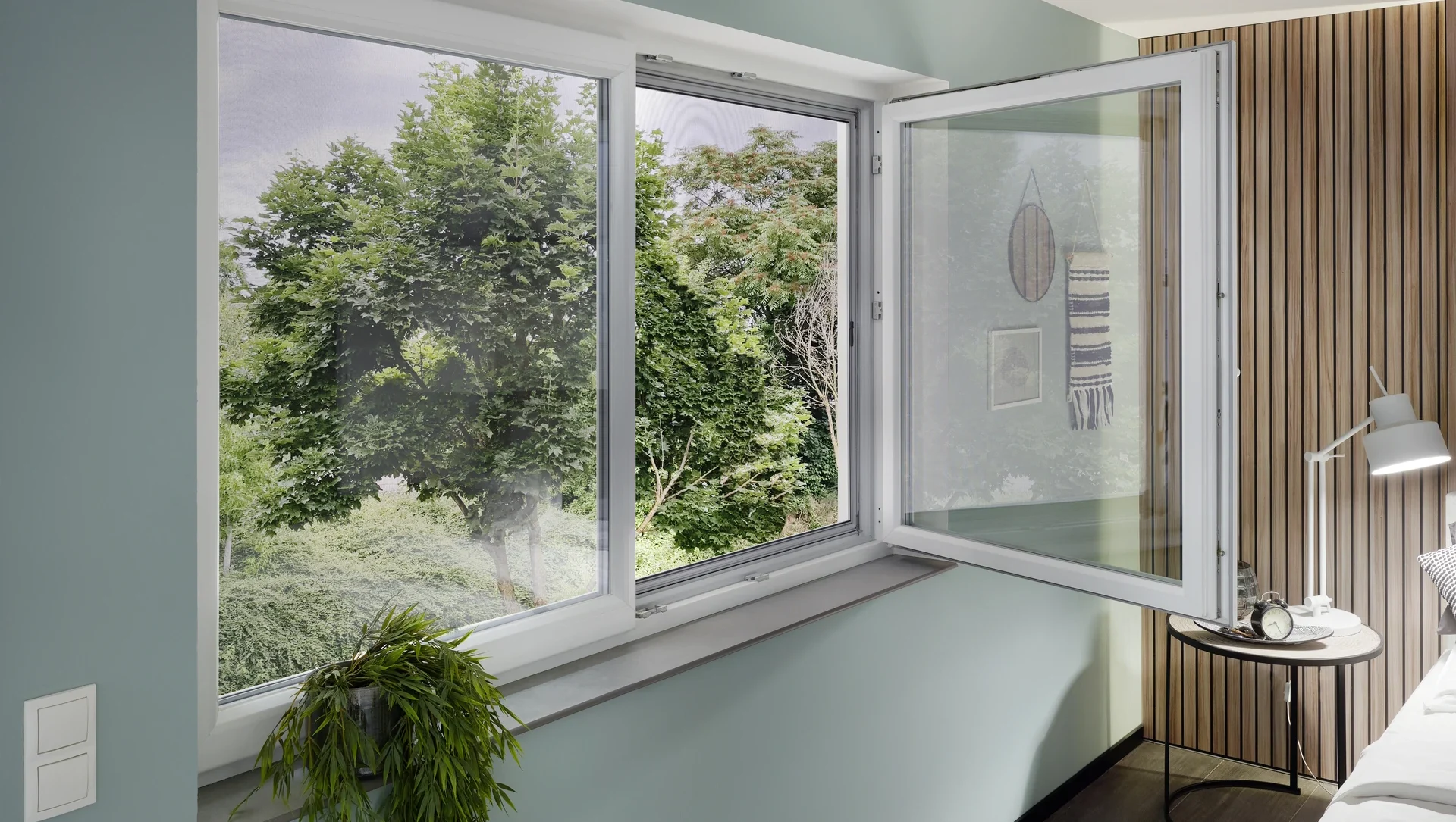 Modernes geöffnetes Fenster mit Blick ins Grüne und Dekoration im Zimmer